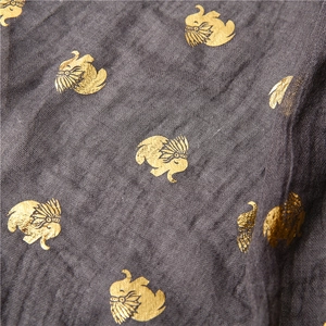 Detail of dark grey cotton linen scarf featuring gold foil elephant patterns and textures