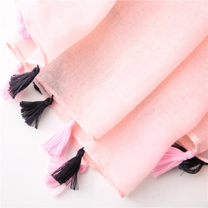 Detail of pink cotton-linen scarf featuring delicate soft fringe tassels and woven texture
