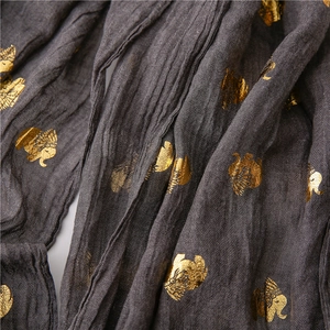 Detail of dark grey scarf showing golden elephant patterns and linen texture fabric