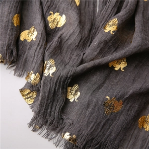 Detail of grey scarf with gold elephant print and handmade tassel edges