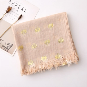 Macro shot of apricot scarf with gold foil elephant patterns and frayed tassel edges