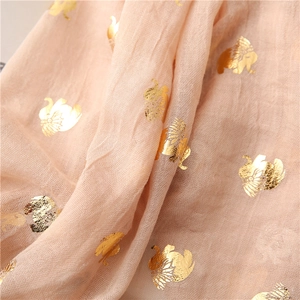 Detail of peach cotton-linen fabric with shimmering gold elephant pattern prints