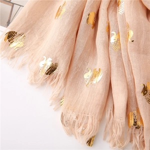 Detail of light pink scarf featuring gold foil elephant prints and raw fringe edges