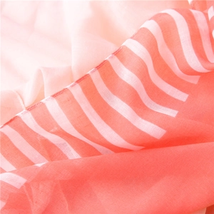 Detailed close-up of striped cotton linen scarf with coral red and white color blocking
