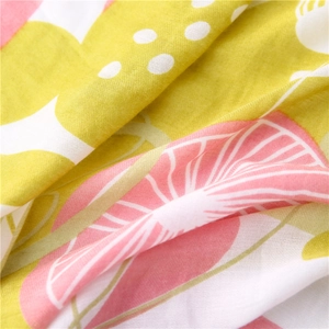 Close-up of soft floral cotton linen fabric with citrus patterns and subtle fringe