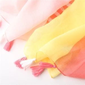 Detail of multi-color cotton linen scarf with yellow and pink fringes for beach sun protection