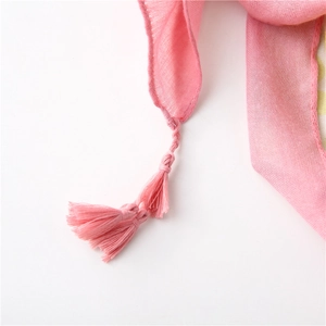 Close-up of pink floral scarf texture showing delicate weave and matching tassel fringe