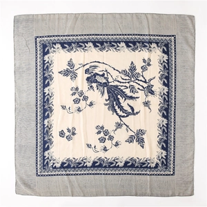 Detail of vintage square scarf featuring blue phoenix and floral prints on off-white fabric