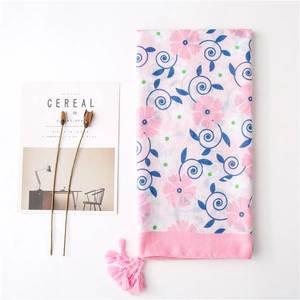 Elegant pink floral scarf with blue scroll patterns and decorative tassel fringe