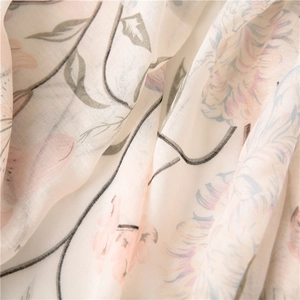 Close-up of floral linen fabric with delicate pink flower patterns and woven texture
