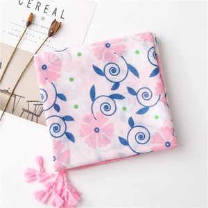 Detail of pink floral scarf with blue swirl patterns and delicate fringe tassels