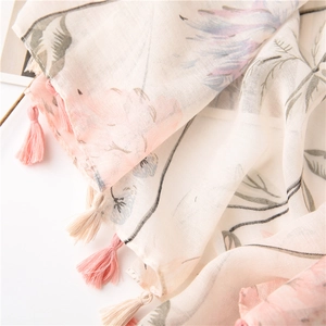 Detail of floral linen scarf showing soft flower prints and delicate fringe tassels