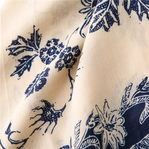 Detail of floral printed linen scarf with blue botanical patterns and breathable texture
