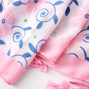 Detail shot of gardenia print cotton scarf showing fabric texture and pink tassels