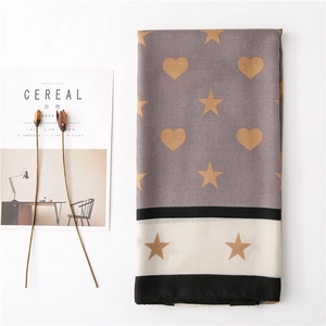 Detail of long scarf with gold heart and star patterns next to Cereal magazine