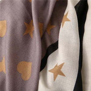 Close-up of printed heart and star patterns on soft textured winter scarf fabric