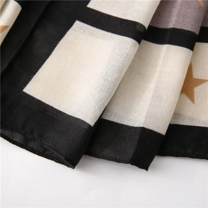 Close-up of black and white checkered scarf with gold star patterns and thin texture