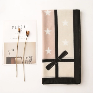 Detailed flat lay of star-patterned color block scarf with dried flower accents