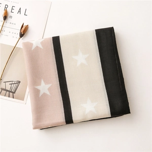 Detail of soft scarf featuring pink and black stripes with white star patterns and magazine