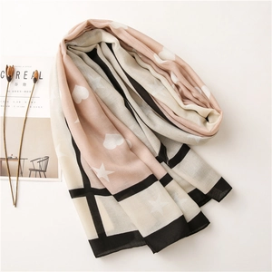 Detail of pink and beige lightweight scarf with star and heart patterns and grid texture
