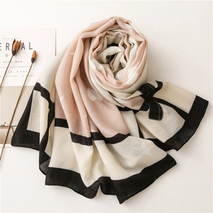 Detail of pink and beige scarf with heart and star prints and bowknot design elements