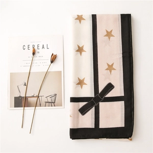 Flat lay of star patterned winter scarf next to cereal magazine and dried flowers