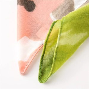 Detailed close-up of pink and green ink wash print on lightweight cotton linen scarf texture