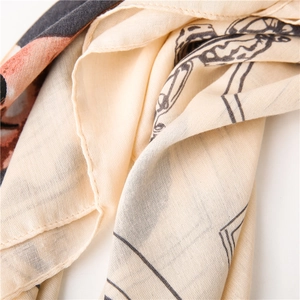 Macro detail of soft cotton scarf showing fine weave texture and orange butterfly patterns