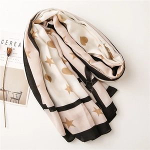 Detail of striped scarf with gold stars and hearts next to lifestyle props