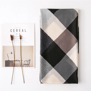 Mise à plat d'une écharpe à carreaux en coton et lin avec fleurs séchées et magazine