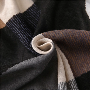 Gros plan d'une écharpe géométrique montrant la texture tissée et le drapé doux
