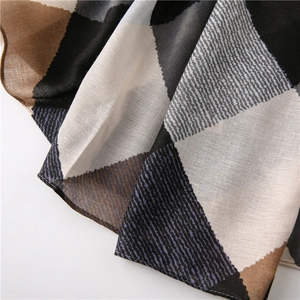 Gros plan détaillé d'une écharpe à motifs de losanges tissés avec blocs de couleurs douces