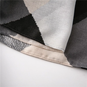 Gros plan détaillé du foulard à motif géométrique montrant la texture et l'ourlet
