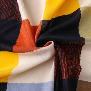 Détail macro du tissu d'écharpe géométrique montrant des textures douces et couleurs