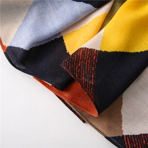 Vue détaillée du tissu de l'écharpe avec motifs géométriques et coutures de précision