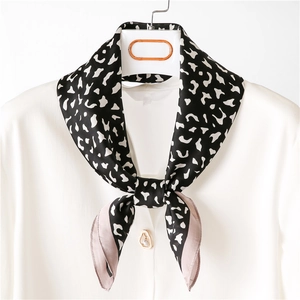 Classic black and white leopard print silk scarf styled on a white shirt with pearl button