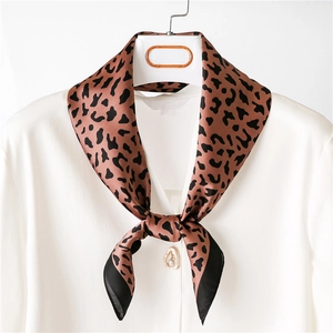 Classic brown leopard print silk square scarf tied on a white shirt collar