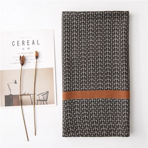 Minimalist geometric patterned scarf with black and grey motifs on white background