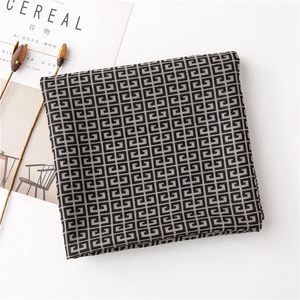 Detail of soft black and grey scarf with G-pattern weave beside a Cereal magazine