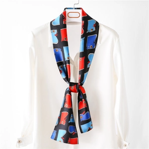 Élégant foulard étroit en soie avec imprimés tendance sur fond de chemise blanche