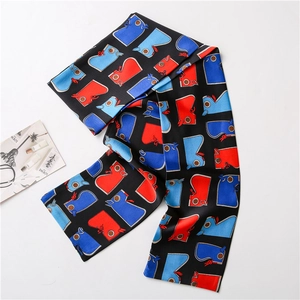 Détail d'un foulard étroit en soie avec imprimés oiseaux colorés sur fond noir uni