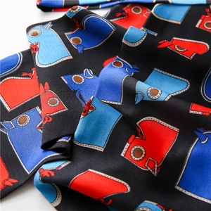 Gros plan sur un foulard en soie noir avec motifs géométriques et drapé élégant