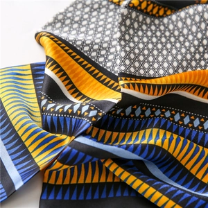 Détail macro d'un foulard en soie avec motifs ethniques et texture satinée