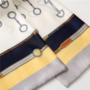Detail of equestrian print silk scarf showing horsebit motifs and satin finish texture