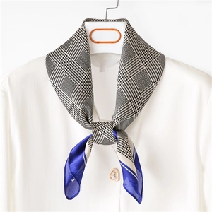 Detailed view of elegant houndstooth silk scarf with royal blue patchwork on white shirt