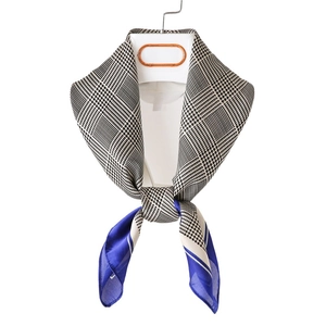 Elegant houndstooth silk scarf in royal blue and black, knotted for autumn fashion style