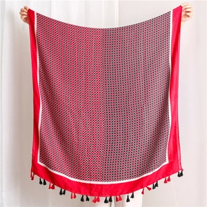 Detail of red geometric diamond pattern scarf with long black and red fringe tassels