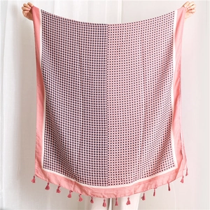 Pink cotton-linen scarf with diamond pattern and tassel trim shown in full view