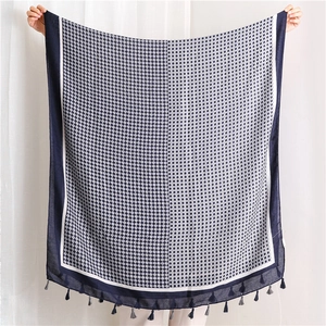 Close-up of geometric diamond pattern on navy blue and grey cotton linen scarf with tassels