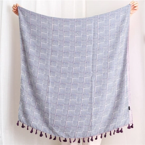 Detailed texture of blue and white houndstooth scarf with purple tassel fringe accents